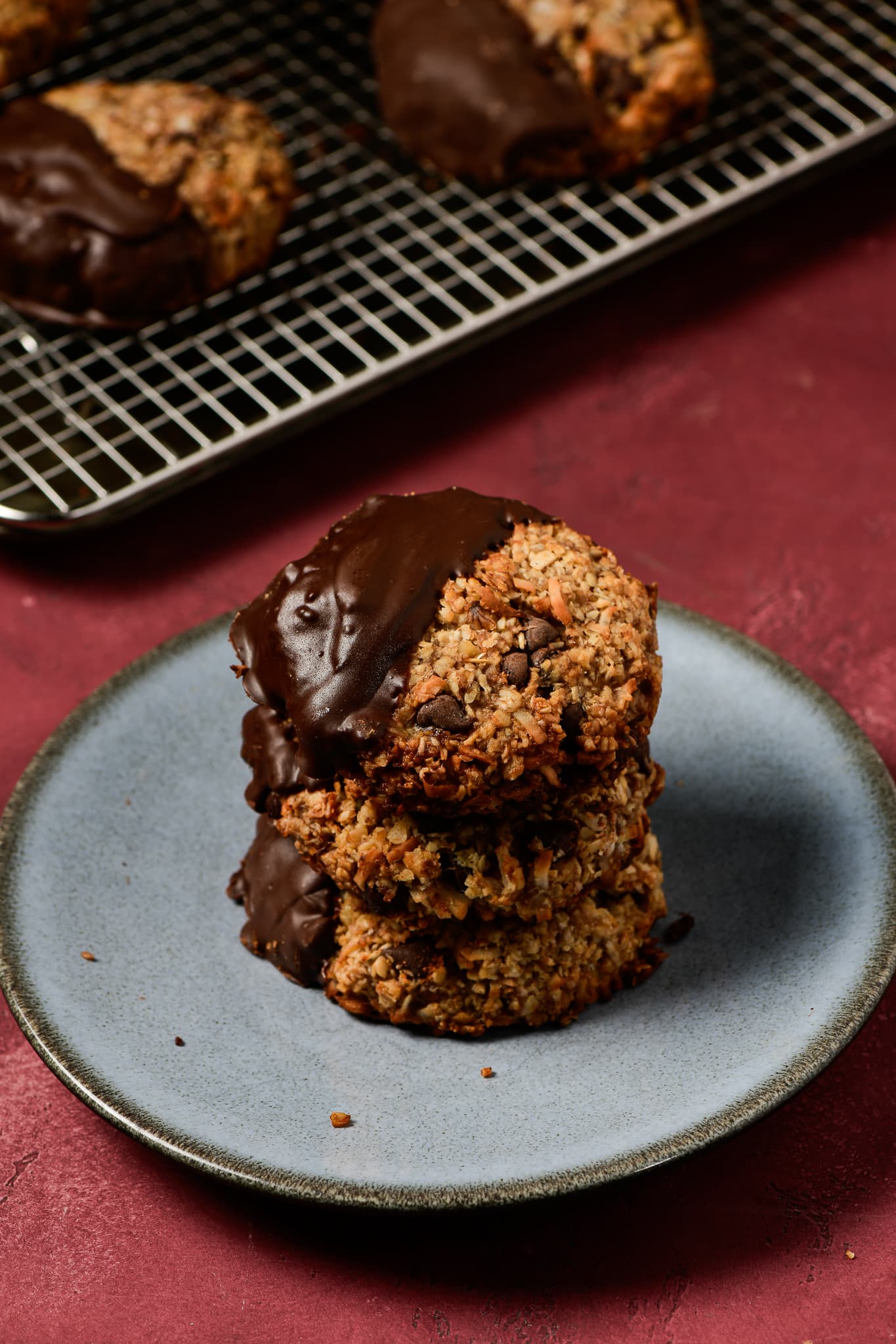 A stack of chocolate-dipped Claudette's cookies on a ceramic plate